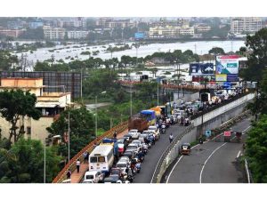 Landscape view of Vasai-Virar showing green spaces, urban buildings, and historic Vasai Fort in the distance.